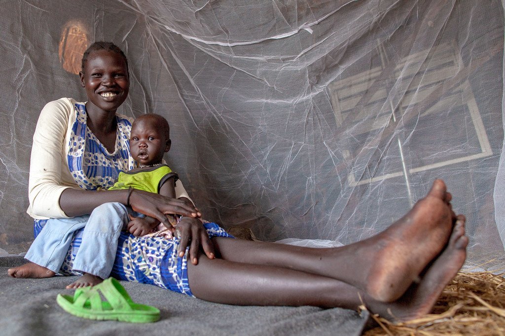 南苏丹上尼罗州，一位母亲和她九个月大的婴儿坐在联合国儿童基金会提供的蚊帐里。