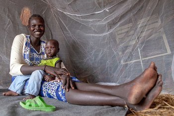 A mother and her nine-month-old baby sit under a UNICEF-supplied bed net in Upper Nile state, South Sudan. 