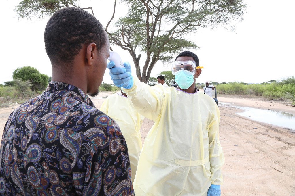 En Somalie, un agent de santé teste un homme pour vérifier sa température dans le cadre de la réponse à la Covid-19