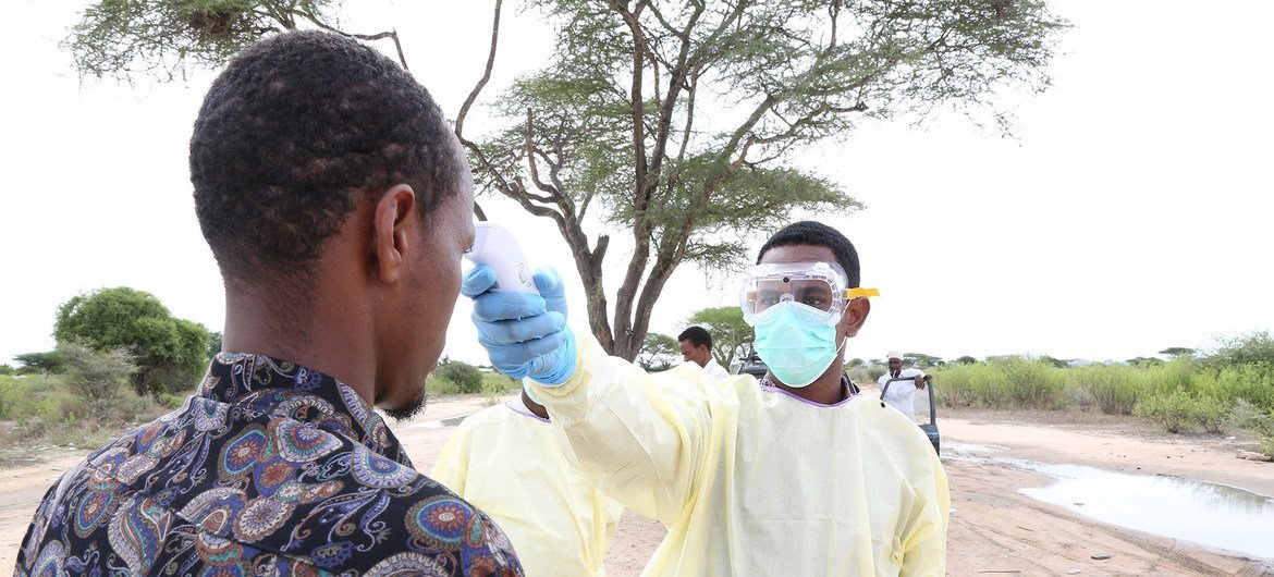 En Somalie, un agent de santé teste un homme pour vérifier sa température dans le cadre de la réponse à la Covid-19