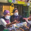 जापान के एक बाज़ार में विक्रेताओं ने फ़ेस मास्क पहना है.