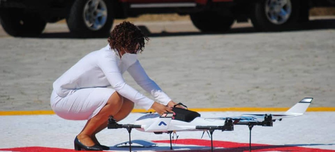 A nurse places a cargo of medical supplies in a drone before take-off.
