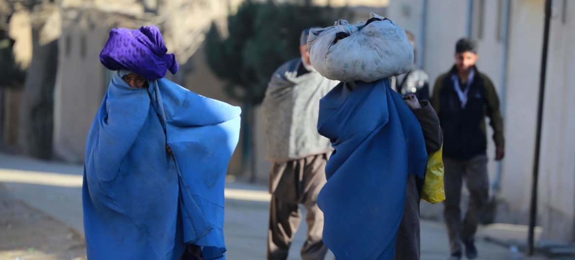 Women carry bundles through a neighbourhood of Kabul, the capital of Afghanistan.