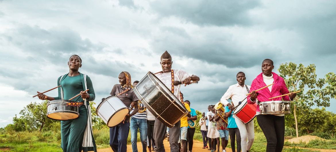 乌干达一个社区铜管乐队正前往一所中学，参加有关保护的主题活动。