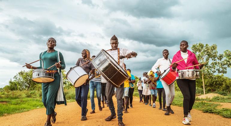 乌干达一个社区铜管乐队正前往一所中学，参加有关保护的主题活动。