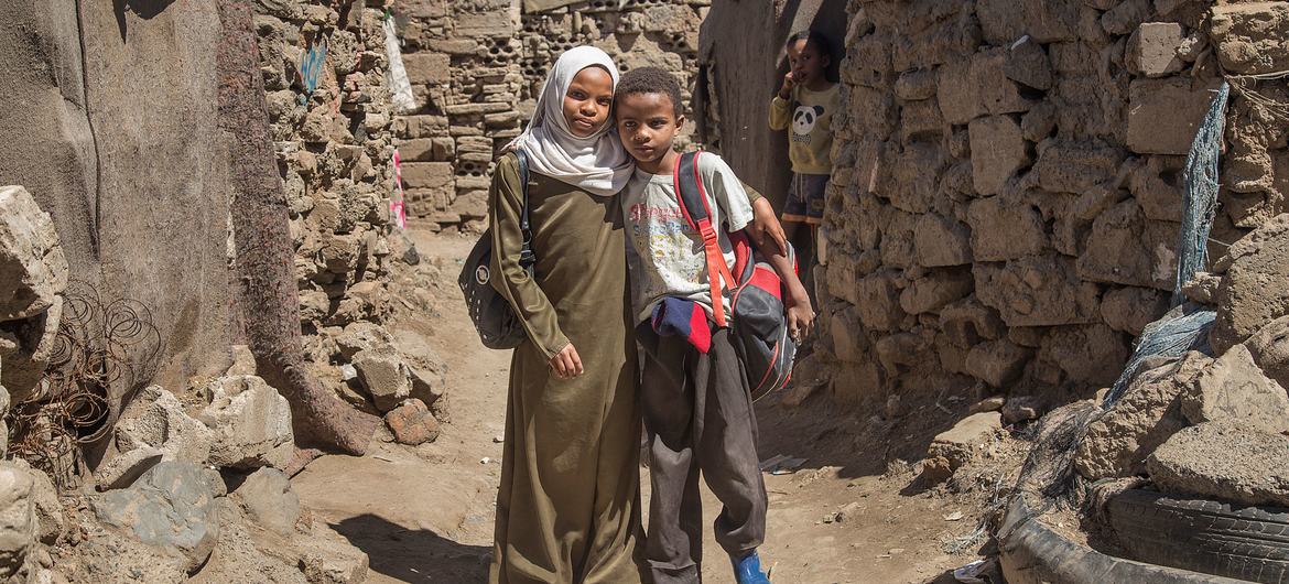 Une fillette yéménite avec son jeune frère qu'elle aide pour ses cours de mathématiques.