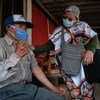 Enfermeira interage com homem indígena em Suba, na Colômbia, durante a pandemia 