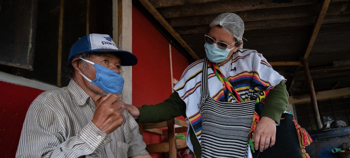 Enfermeira interage com homem indígena em Suba, na Colômbia, durante a pandemia 