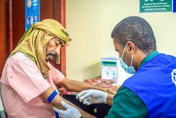 A doctor treats a patient while wearing PPE to stop COVID-19 transmission in an IOM-supported health centre in Aden City, Yemen.