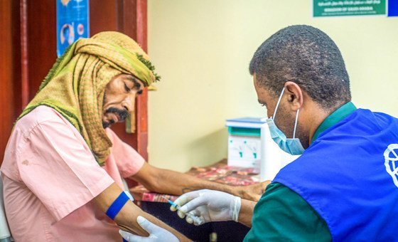 A doctor treats a patient while wearing PPE to stop COVID-19 transmission in an IOM-supported health centre in Aden City, Yemen.