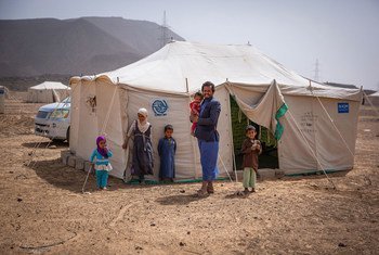 A father stands with his children outside their tent in a displacement site outside Marib City, Yemen (file photo).
