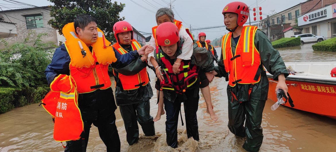 Los trabajadores de emergencia rescatan a una persona mayor en Xuchang, en la provincia china de Henan.