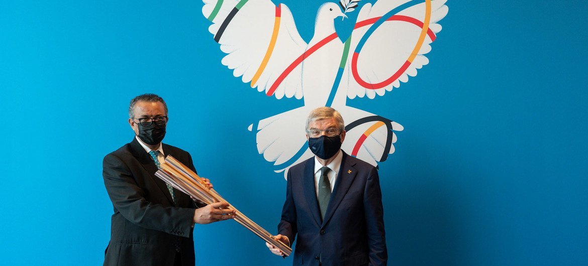 अन्तरराष्ट्रीय ओलिम्पिक समिति के अध्यक्ष थॉमस बाख के साथ यूएन स्वास्थ्य एजेंसी के प्रमुख टैड्रॉस एडहेनॉम घेबरेयेसस.