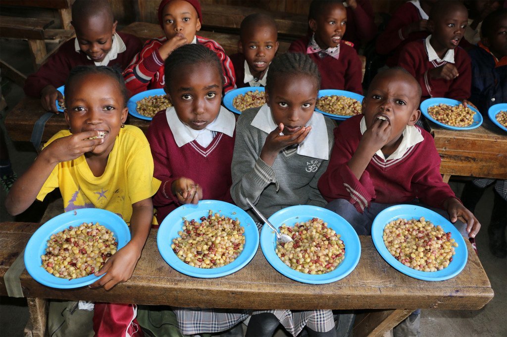 Niños en Kenia disfrutan de un almuerzo hecho con vegetales que habrían sido tirados por no ser estéticamente aceptables para exportar.