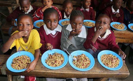 Kenyan school children enjoy a lunch made with unusually shaped vegetables which were deemed not good enough for export.