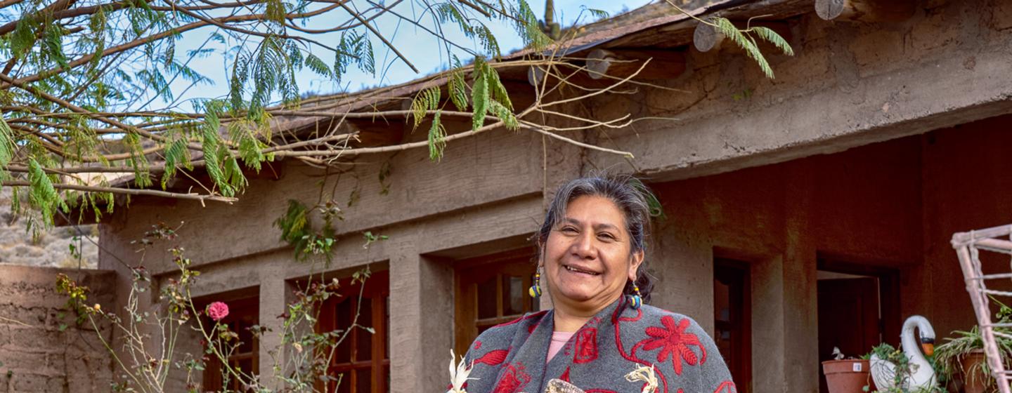 Indigenous Argentinian tourism entrepreneur  Hero photo alt text  Celestina Ábalos stands outside her home.