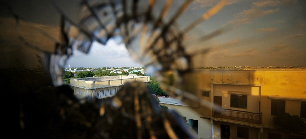 Vue de la banlieue nord de Mogadiscio, en Somalie, à travers la vitre d'un hôtel brisée par une balle.