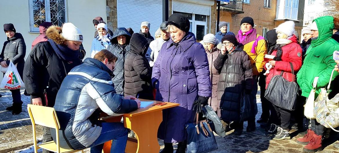 تقف النساء الهاربات من مناطق القتال في إقليمي دونيتسك ولوهانسك في طابور لتلقي المساعدات الإنسانية.