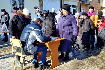 Des femmes ayant fui les zones de combat dans la régions de Donetsk et Louhansk, en Ukraine, attendent de recevoir de l'aide humanitaire.