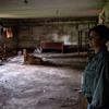 A woman stands in the basement shelter of the severely damaged school where she is deputy principal.