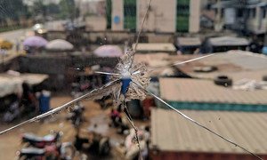 مشهد من مدينة لاغوس النيجيرية من خلال نافذة زجاجية مشروخة بفعل الرصاص.
