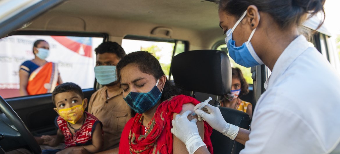 भारत में, मध्य प्रदेश के झाबुआ ज़िले के एक टीकाकरण केन्द्र पर एक महिला को कोविड-19 वैक्सीन का पहला टीका लगाए जाते हुए.
