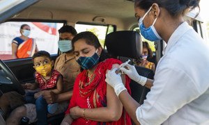 Une femme reçoit sa première dose de vaccin covid 19 dans un centre de vaccination "drive-in" au MP Tourism Motel à Jhabua, Madhya Pradesh.