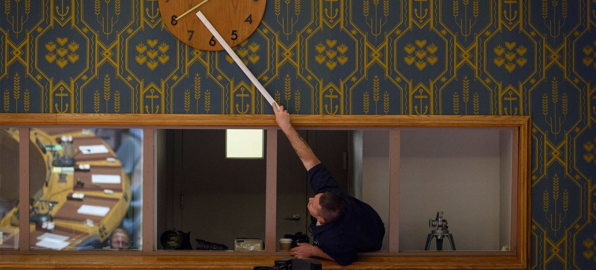 一名联合国工作人员正在调整安理会会议厅内的时钟。（2019年11月图片）