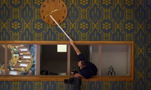一名联合国工作人员正在调整安理会会议厅内的时钟。（2019年11月图片）