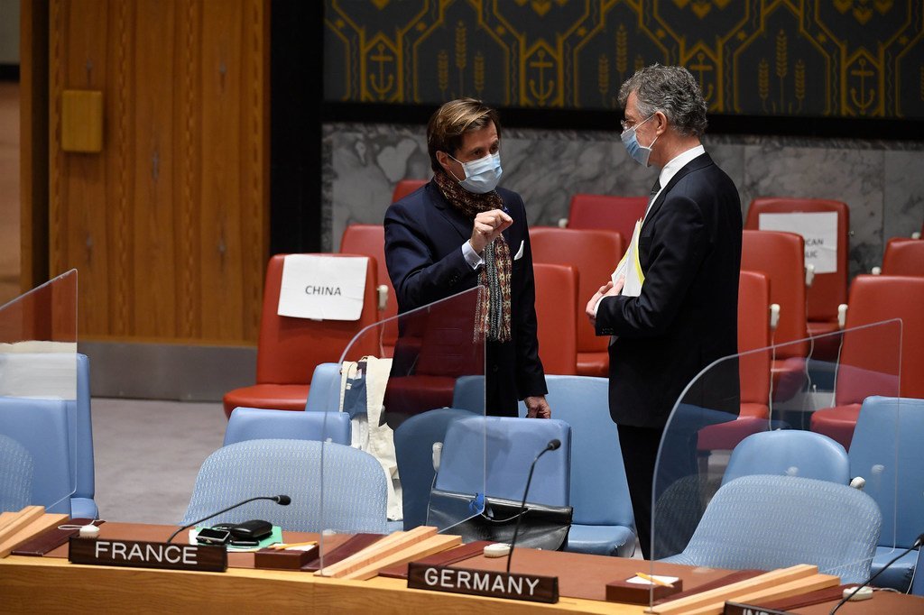 法国常驻联合国代表德里维埃（左）在安理会会议厅内与德国常驻联合国代表霍伊斯根交谈。根据联合国防疫规定，二人均佩戴口罩。（2020年11月12日图片）