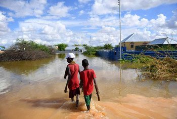 Young boys walk through a section of a flooded residential area in Belet Weyne, Somalia.