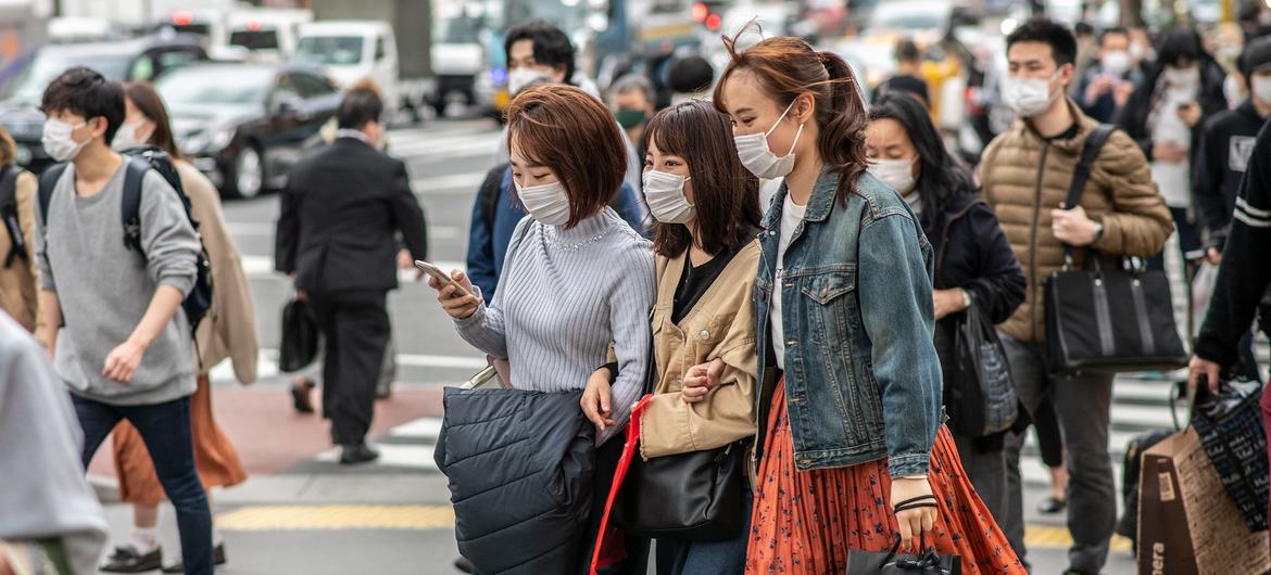 जापान के टोकयो शहर में, मास्क पहने हुए लोग