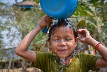 一名柬埔寨儿童在家中新安装的水龙头前洗脸。