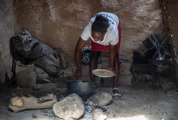 Mulher prepara refeição no Haiti. 