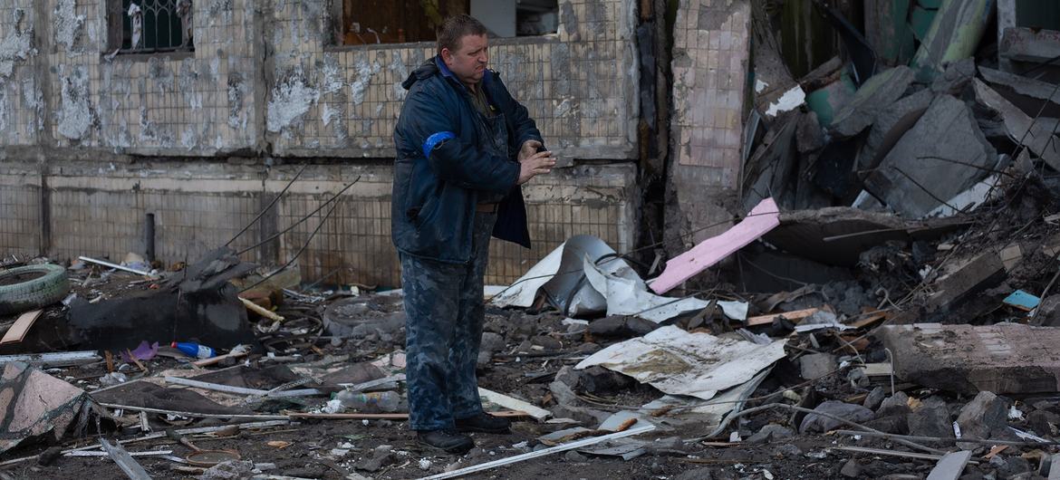 Un hombre retira los escombros alrededor de un edificio residencial en Kyiv, Ucrania.