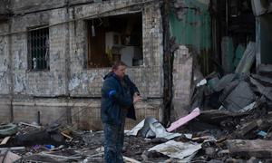 Un homme retire des débris d'un bâtiment résidentiel à Kyïv, en Ukraine.