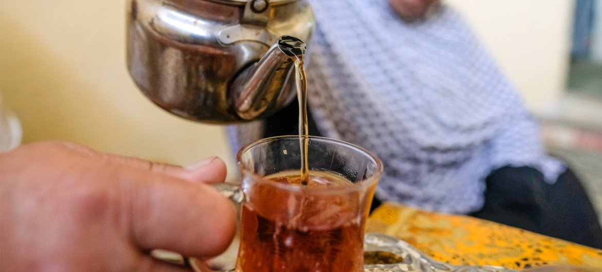 一名巴勒斯坦难民在约旦的难民营内与家人一同饮茶。