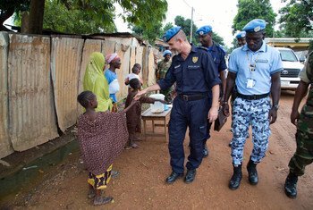 Conselheiro da Polícia da ONU, Luis Carrilho, cumprimenta uma criança durante sua patrulha a pé pelas ruas de Bangui