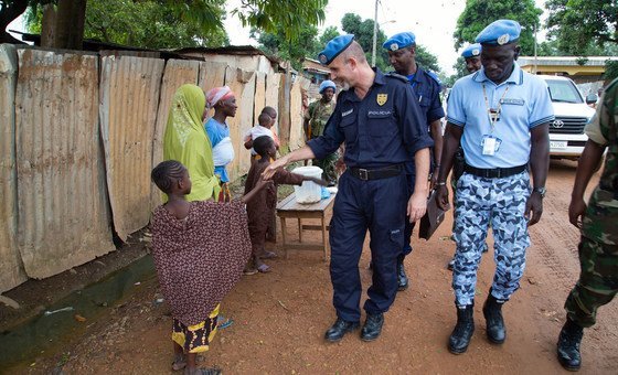 Current UN Police Adviser and former MINUSCA Police Commissioner, Commissioner Luis Carrilho (center), greets a child during his foot patrol through the streets of Bangui..