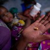 أم في مبارارا، غرب أوغندا، تتأكد من أن يتلقى طفلاها دواء فيروس نقص المناعة البشرية للأطفال في نفس الوقت كل يوم.