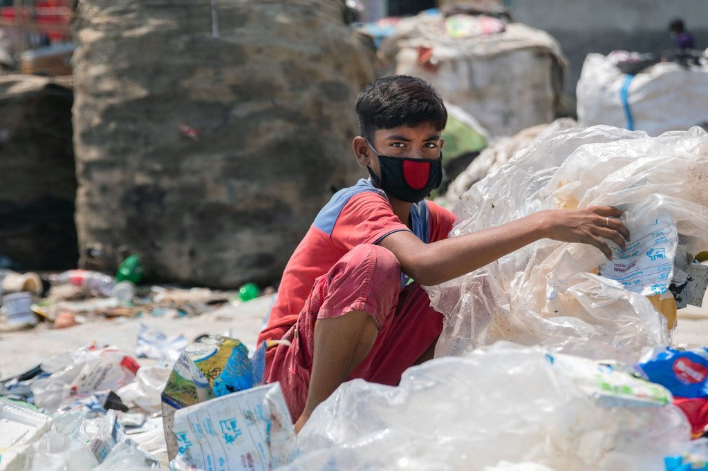 Un garçon âgé de 12 ans à Dhaka, au Bangladesh, trie des ordures pour aider sa famille.