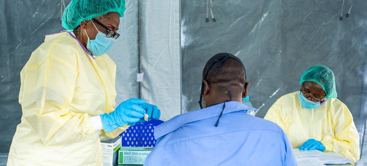 أحد العاملين الصحيين في جمهورية الكونغو الديمقراطية يقوم بتطعيم رجل بلقاح ضد فيروس كورونا.