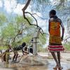 肯尼亚图尔卡纳县，一名年轻女孩在沙坝附近操作手摇水泵。