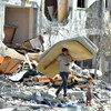 गाज़ा पट्टी में इसराइली कार्रवाई में क्षतिग्रस्त घर से सामान निकालता एक फ़लस्तीनी किशोर.