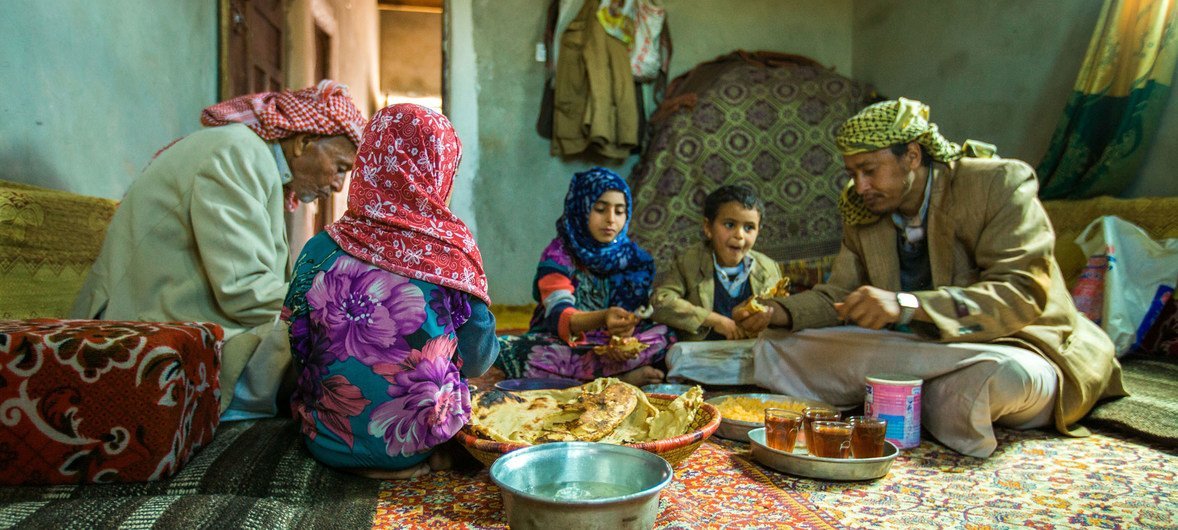 With money received through the UNICEF emergency cash transfer project, a family from Amran Governorate in Yemen shares lunch.