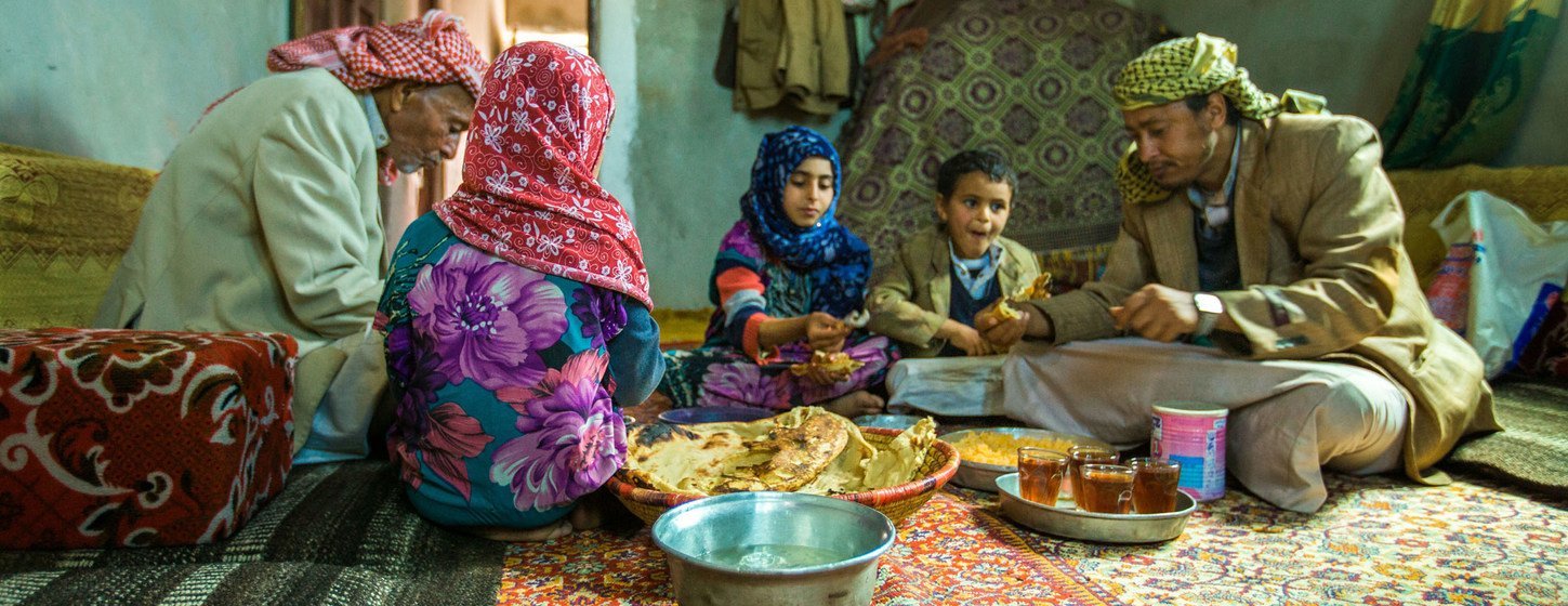Com o dinheiro recebido através do projeto de transferência de renda emergencial da Unicef, uma família da província de Amran, no Iêmen, compartilha o almoço.