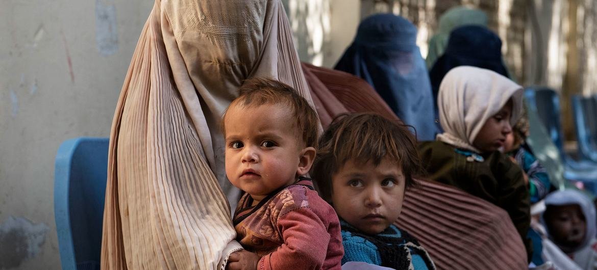 अफ़ग़ानिस्तान के कन्दहार में चिकित्सा परामर्श के लिये स्वास्थ्य केंद्र पर एक महिला व बच्चे.