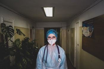 यूक्रेन की राजधानी कीयेव में एक स्वास्थ्यकर्मी निजी बचाव परिधान व उपकरणों (PPE) के साथ.