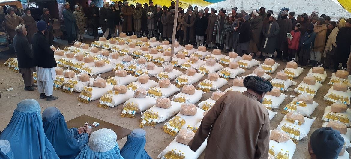 People wait in line for food and oil being distributed by the World Food Programme in Andkhoy, Afghanistan.