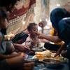 طفل عمره سنة يتناول الطعام مع أسرته في مخيم للنازحين داخليا في عدن، اليمن.